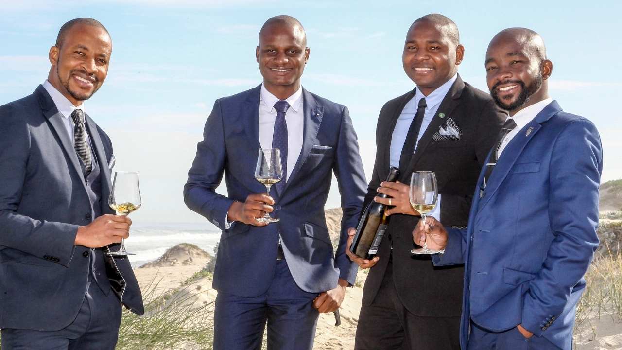 four men holding wine glasses